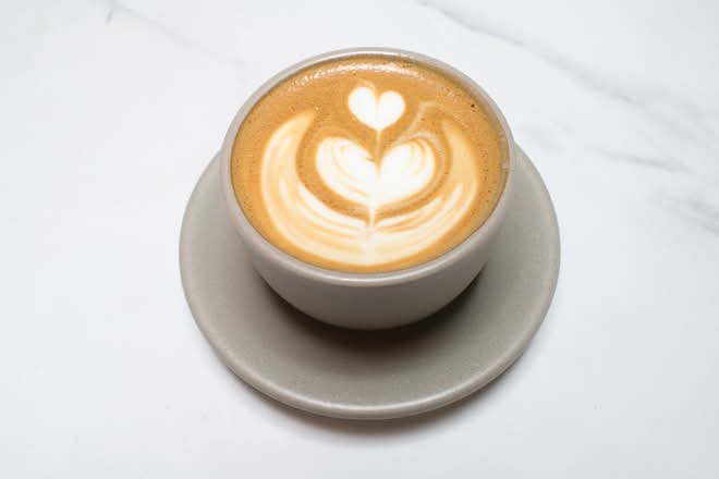 Flat white with latte art in a grey cup